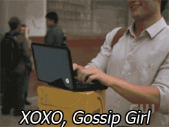 Dan Humphrey stands on the streets of New York typing on a small laptop