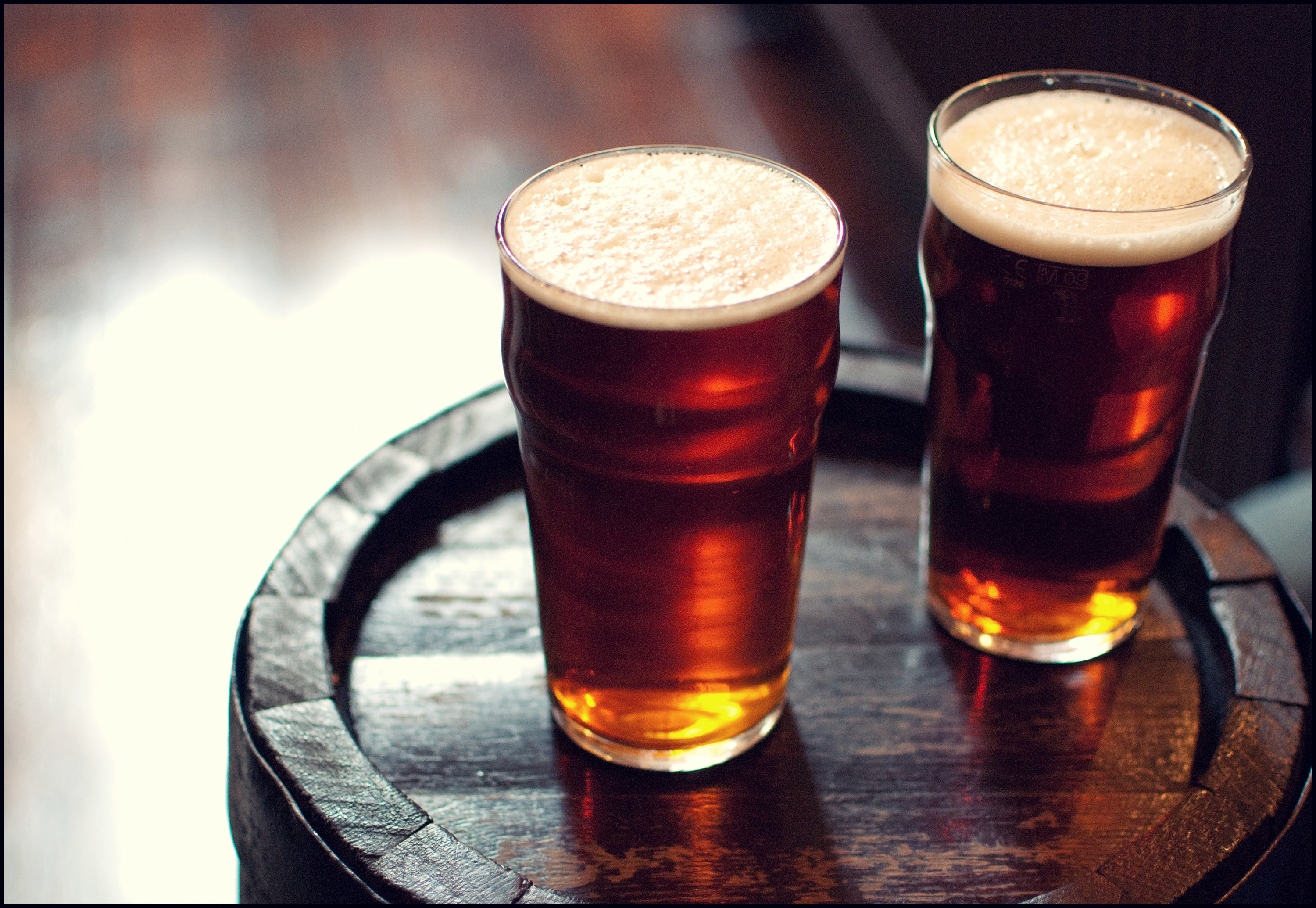 Two glasses of beer sitting on a table