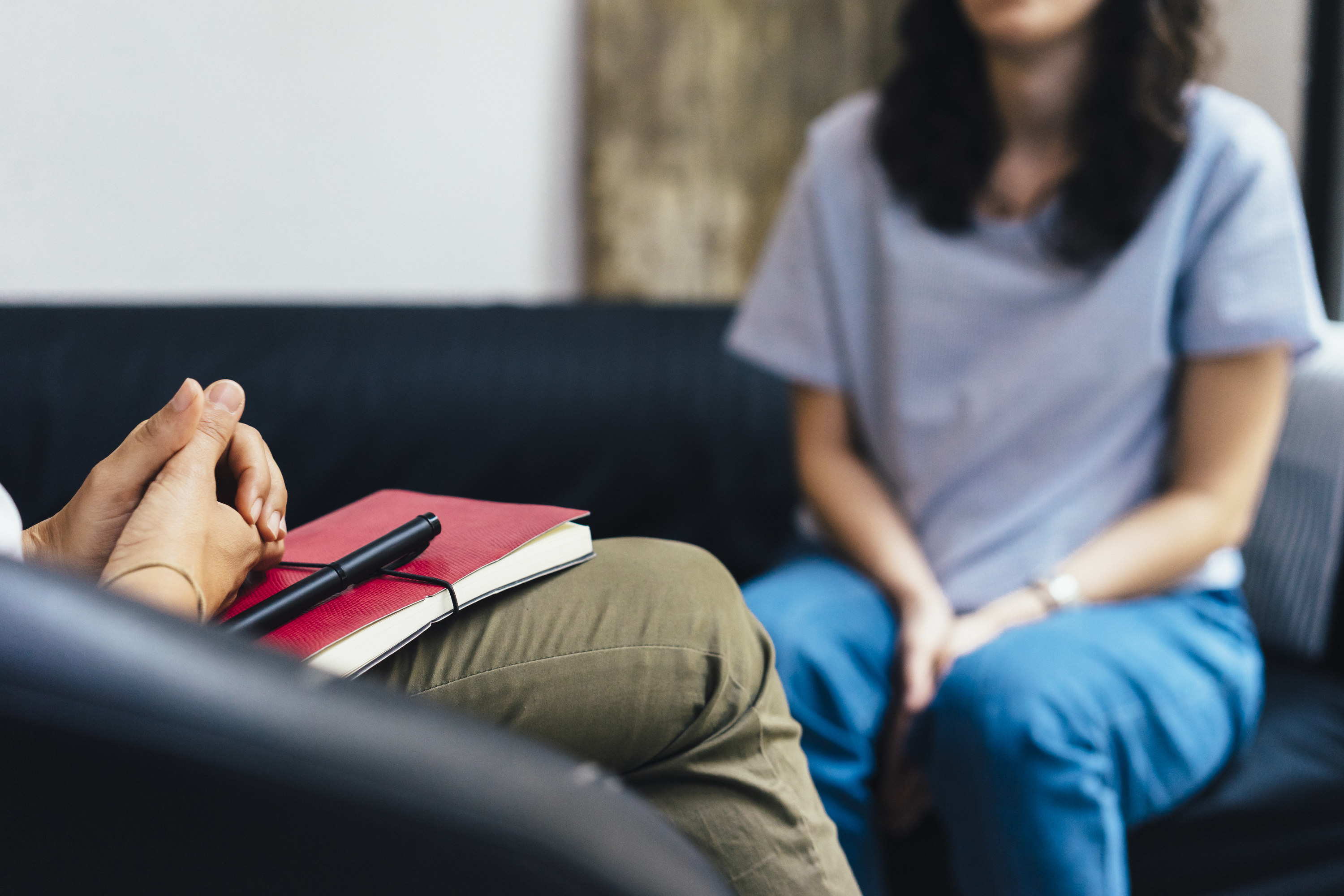 A person sitting on a couch speaking to a therapist