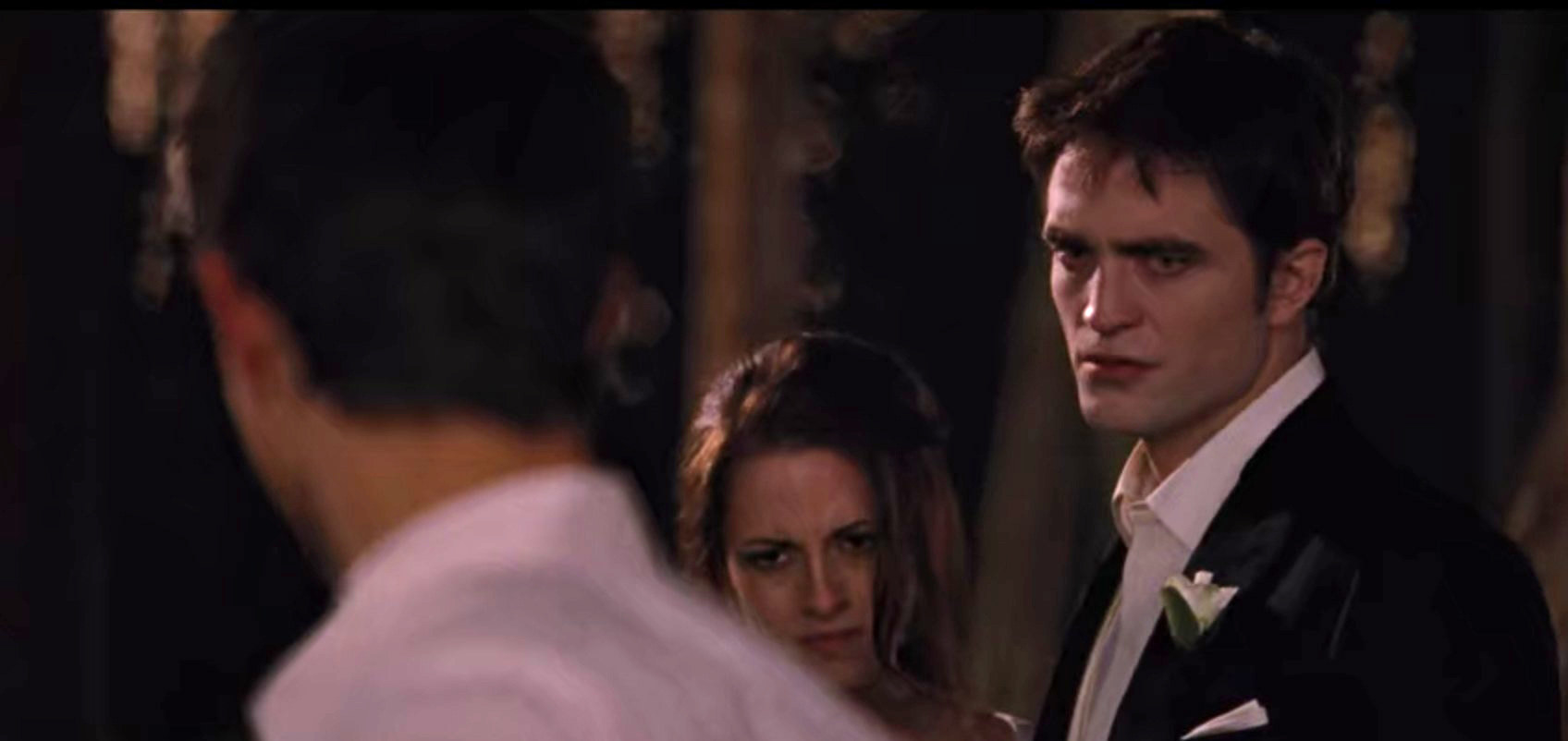 Edward furrows his brows in anger at Jacob while Bella looks forward, pain in her eyes