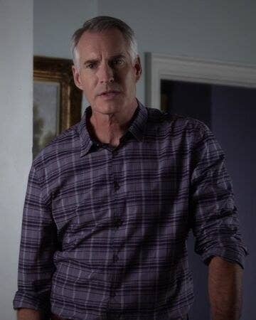 Kenneth DiLaurentis leans a bit to the side as he stands in the living room of his house