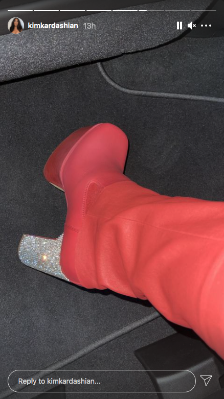 Kim Kardashian takes a picture of her red boots with sparkly heels at Kanye West&#x27;s album listening event