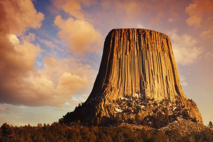 Devils Tower with parallel cracks lit by sunrise