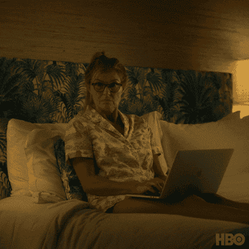 Connie Britton&#x27;s jaw drops as she sits in bed working on her laptop