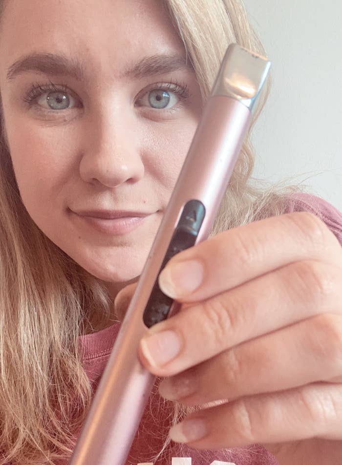 BuzzFeed editor holding rose gold stick-shaped lighter
