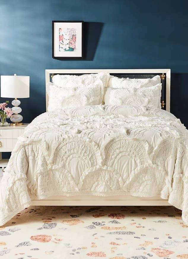A cream, ruffled quilt atop a bed