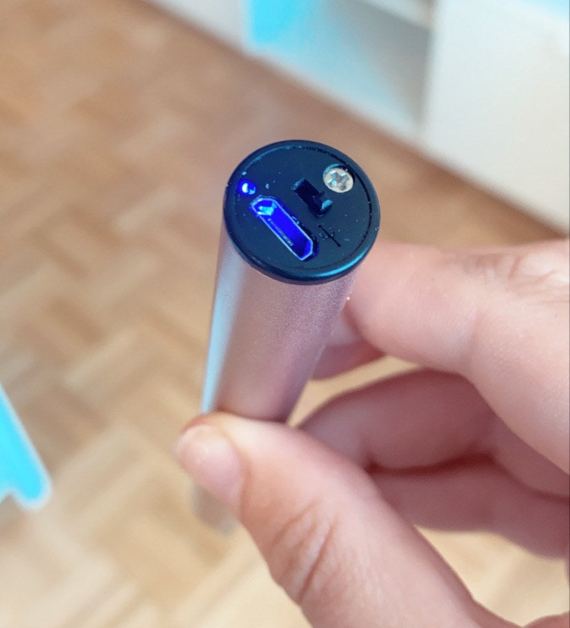 BuzzFeed editor showing the bottom of the lighter with the safety switch and blue light on
