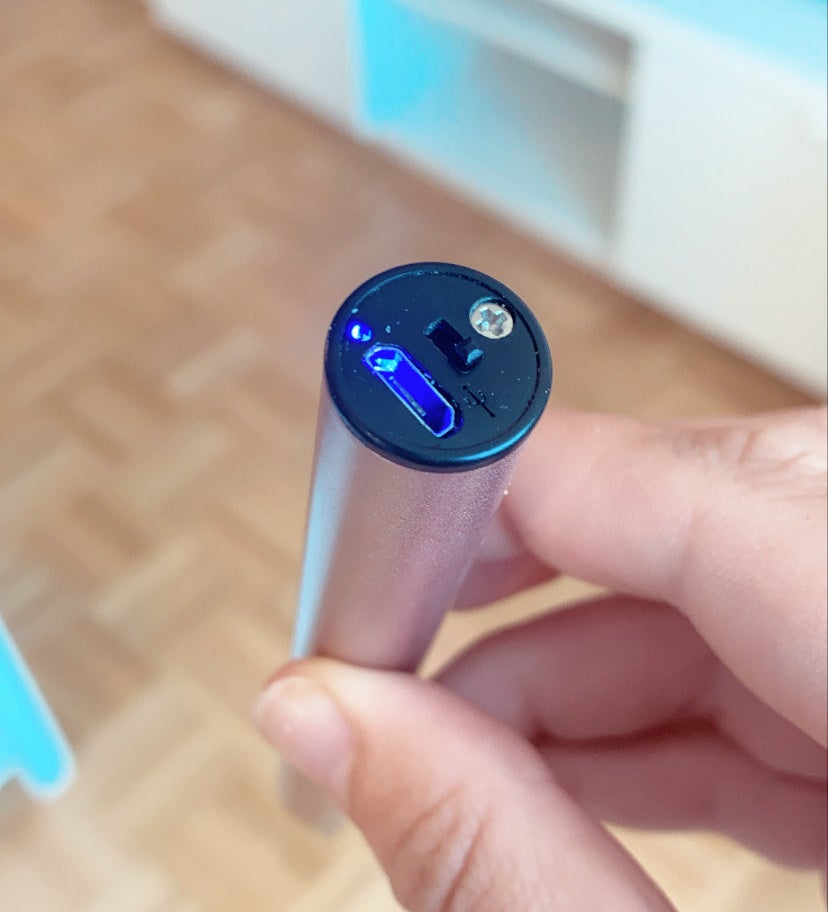 BuzzFeed editor showing the bottom of the lighter with the safety switch and blue light on