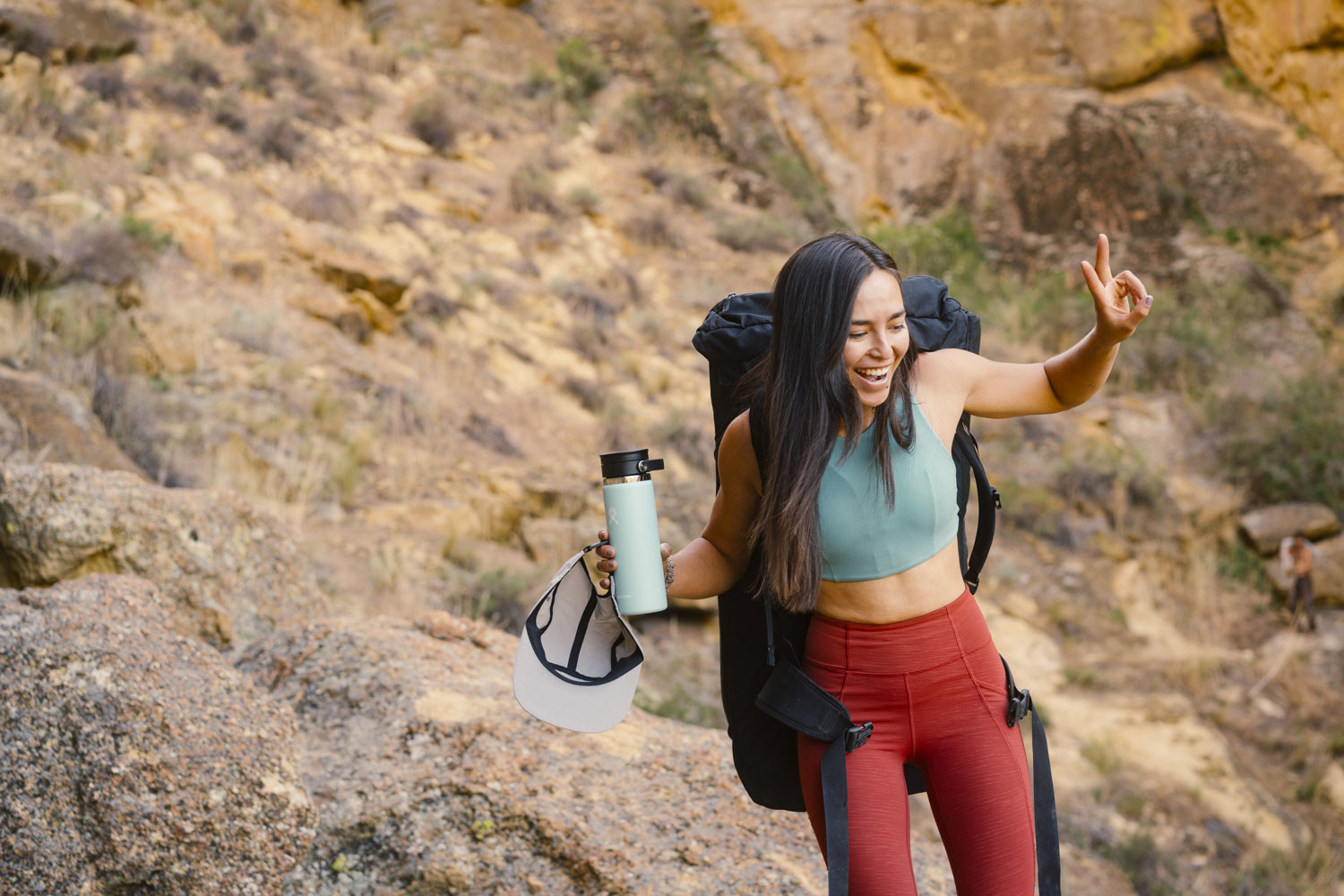 woman hiking and holding a Hydro Flask water bottle.