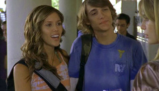 kasey annd jonny stand in a school hallway talking to marissa