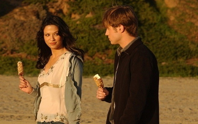 teresa and ryan walk through a field while holding ice cream