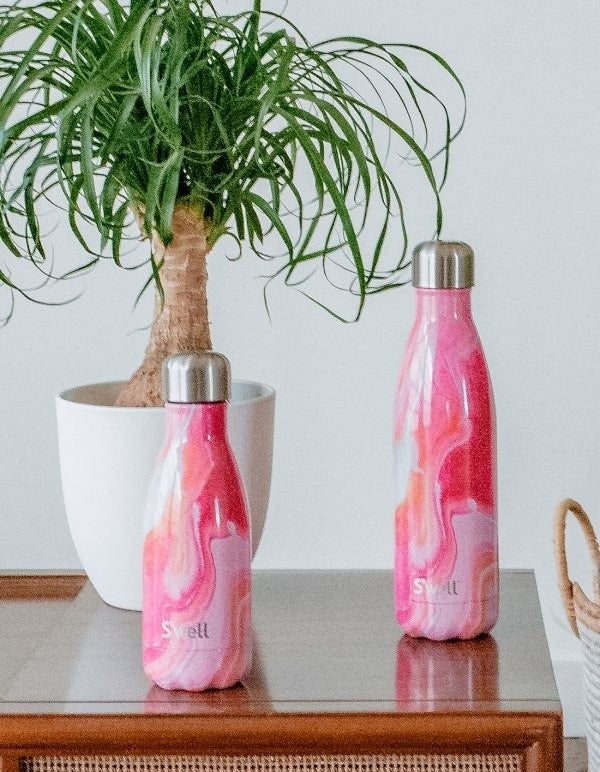 the pink agate bottle in two sizes on a table