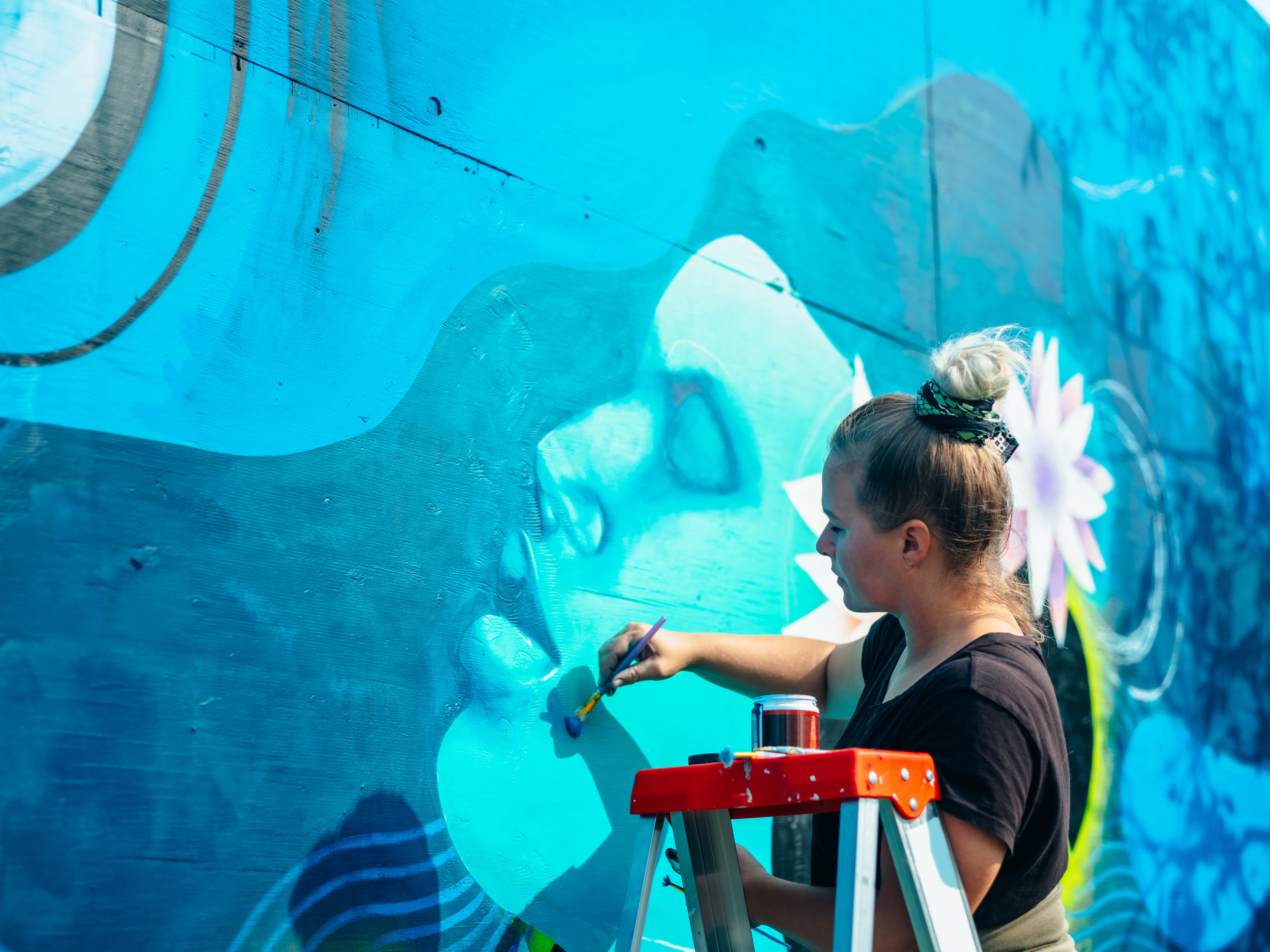 Woman painting a mural on a wall
