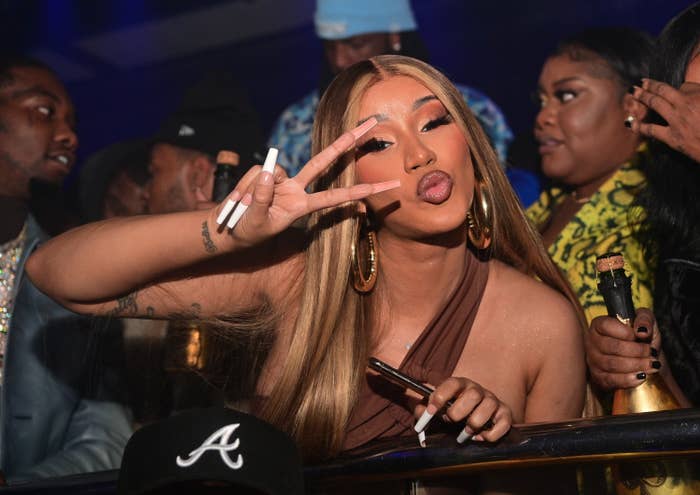 Cardi throwing the peace sign