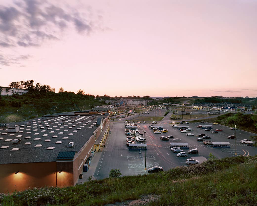 A parking lot with a number of cars at a strip mall