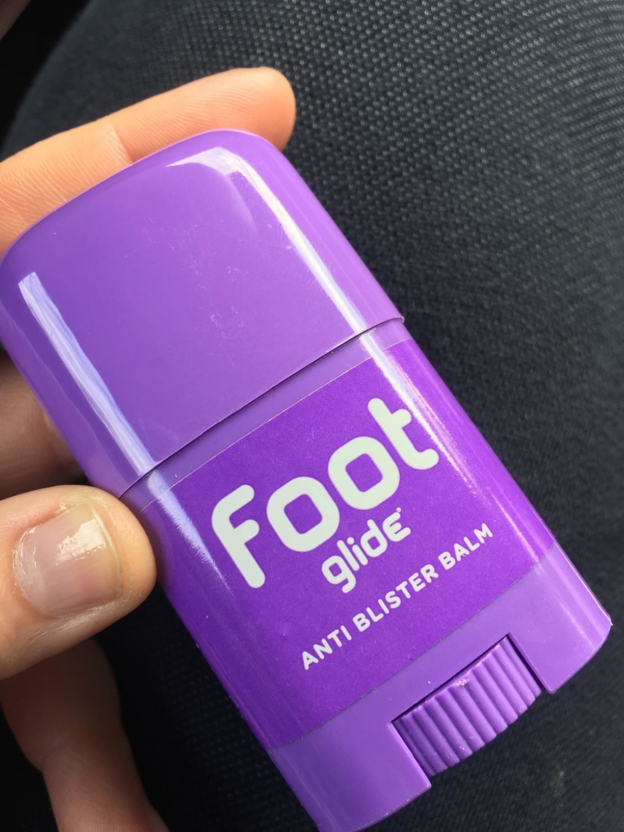reviewer&#x27;s hand holding the roll on foot glide anti blister balm