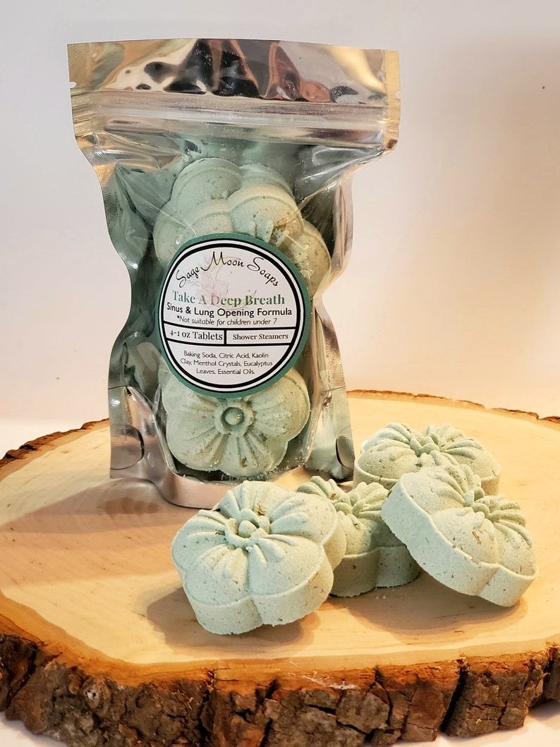 a packet of the shower steamers which are pastle green and shaped like flowers