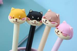 pens topped with mean looking shiba heads