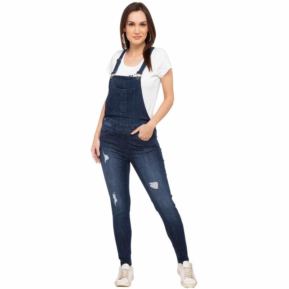 A woman wearing denim overalls over a white top
