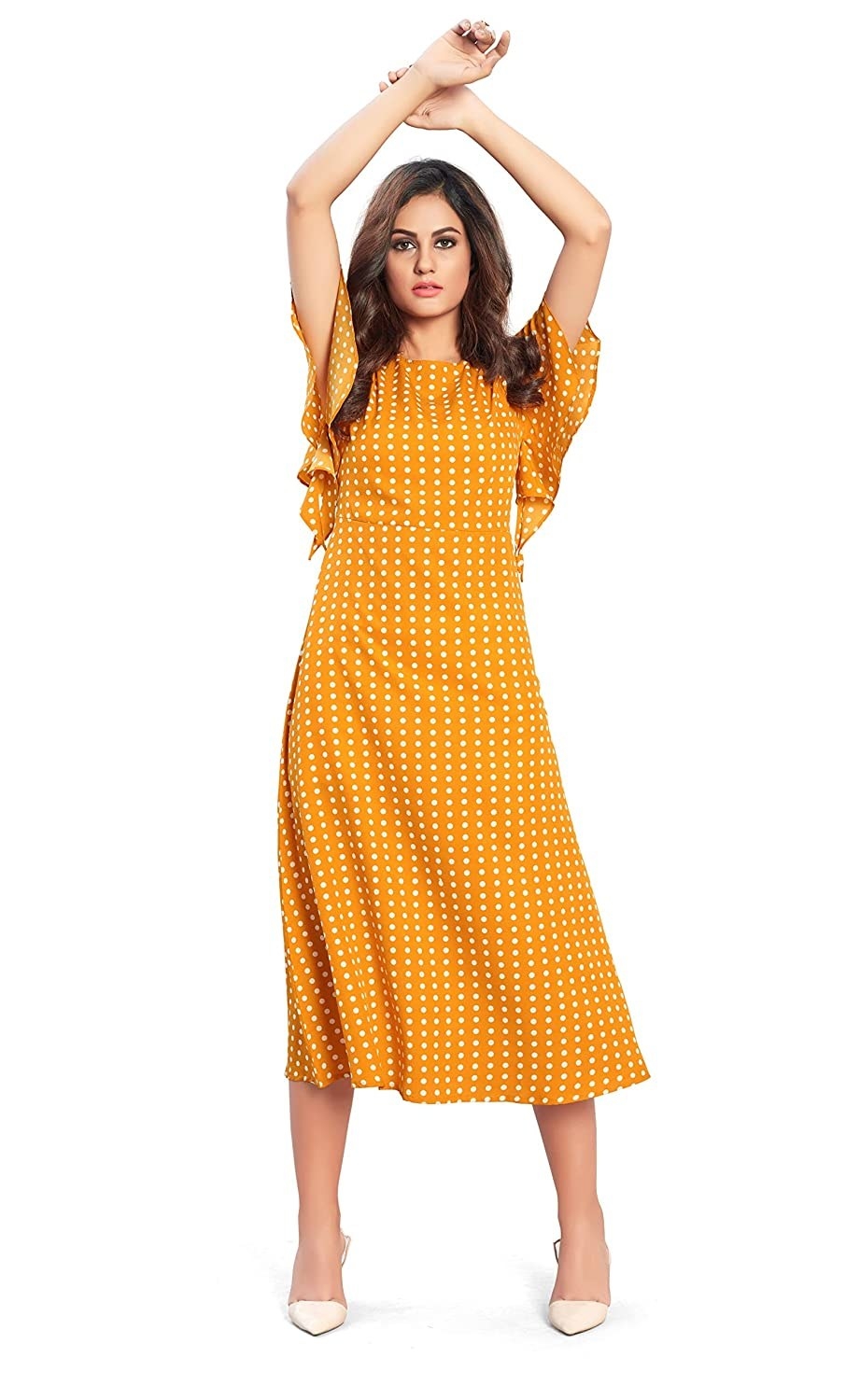 A woman wearing a yellow polka dot dress with heels