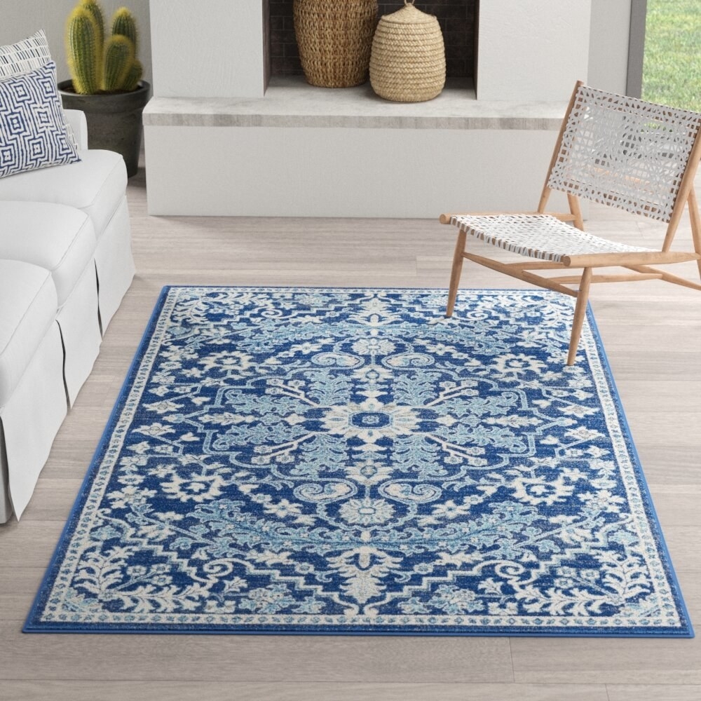 the blue and white patterned rug in a living room