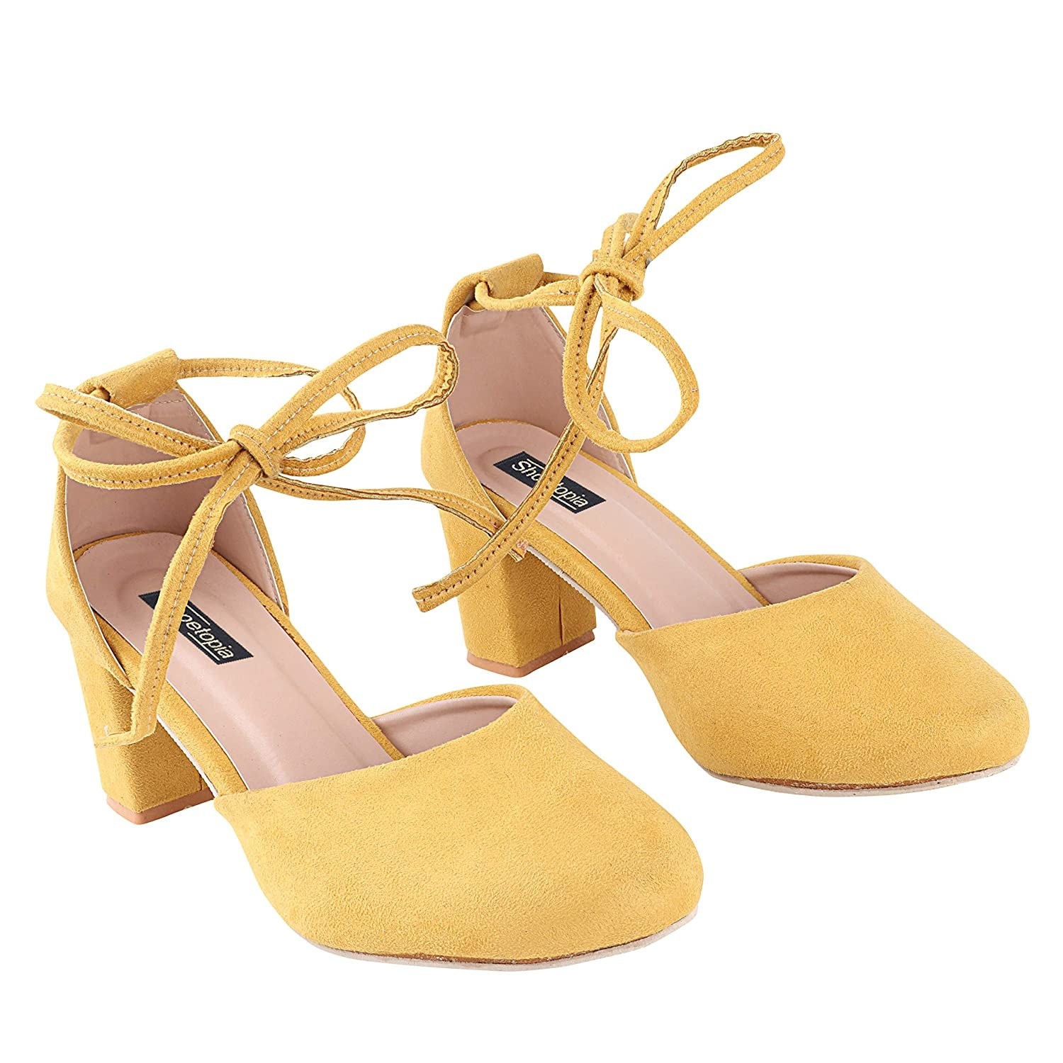 A pair of yellow suede heels with a tie-up straps around the ankles