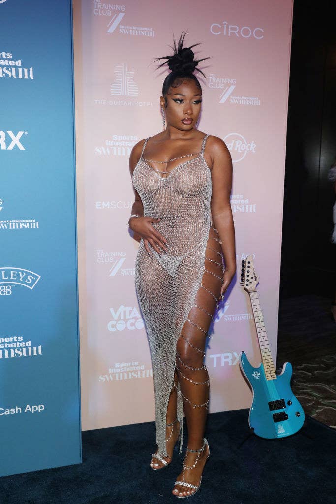 Megan wearing a see-through mesh gown with a thigh-high slit