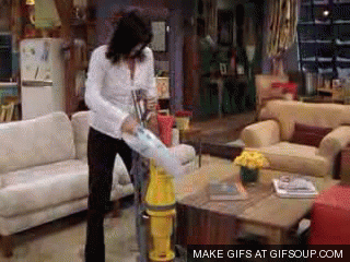 Gif of Monica Geller cleaning a bigger vacuum with a smaller vacuum.