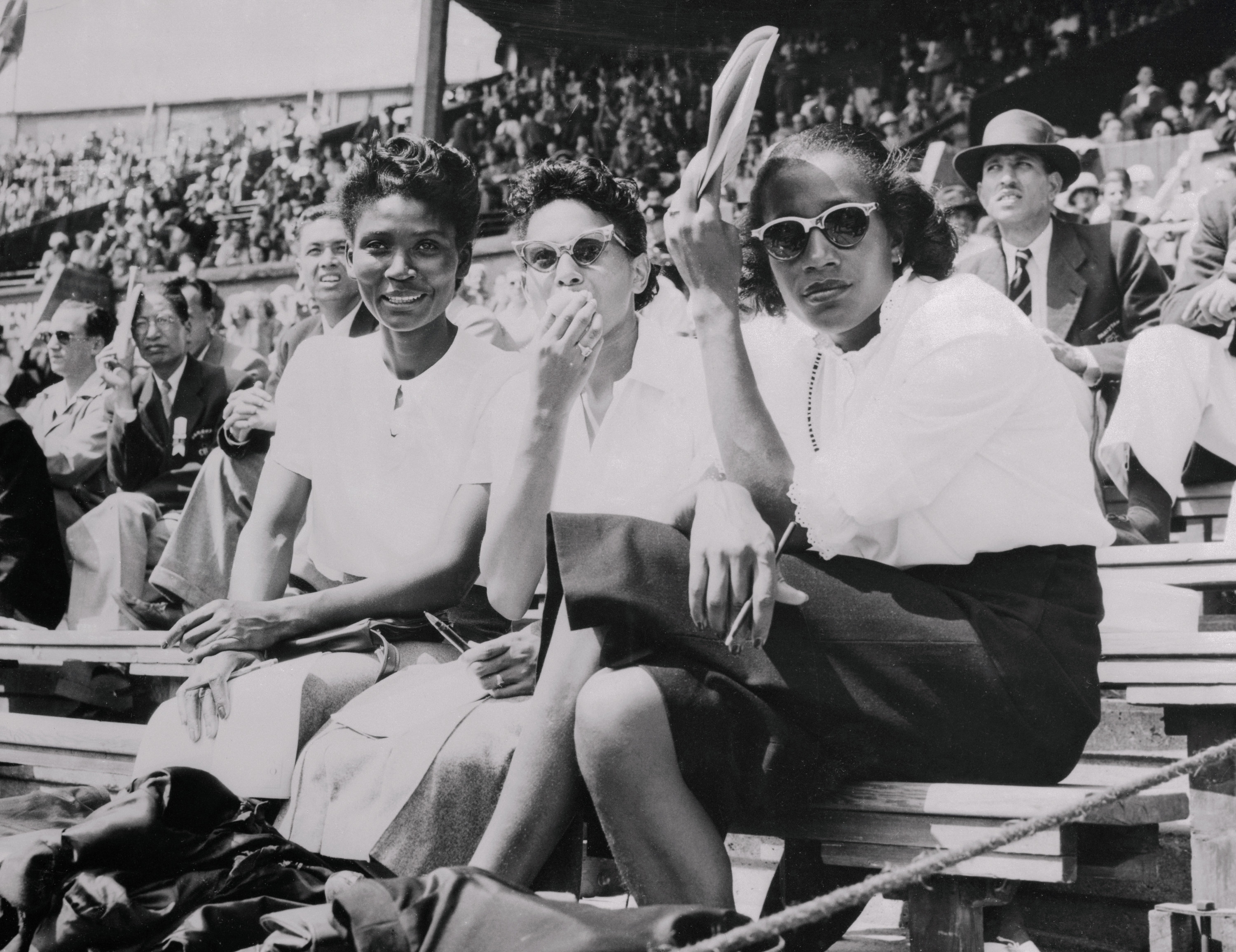 Audrey Patterson, Alice Coachman and another woman sit with the spectators at the 1948 Olympics