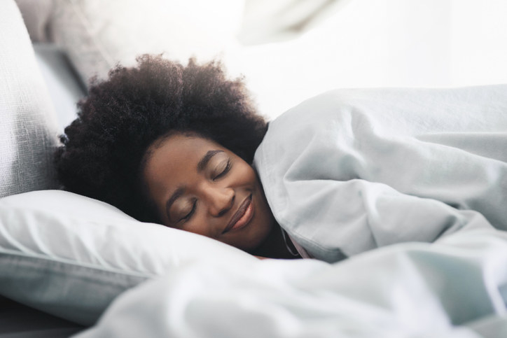 A person smiling as they lie in bed
