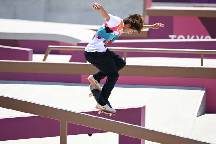 Yuto skateboarding down a handrail, arms raised, no helmet