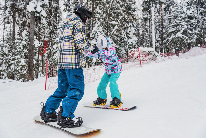 Snow board instructor with a young student