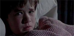 Haley Joel Osment in The Sixth Sense, wrapped up in a blanket, looking scared