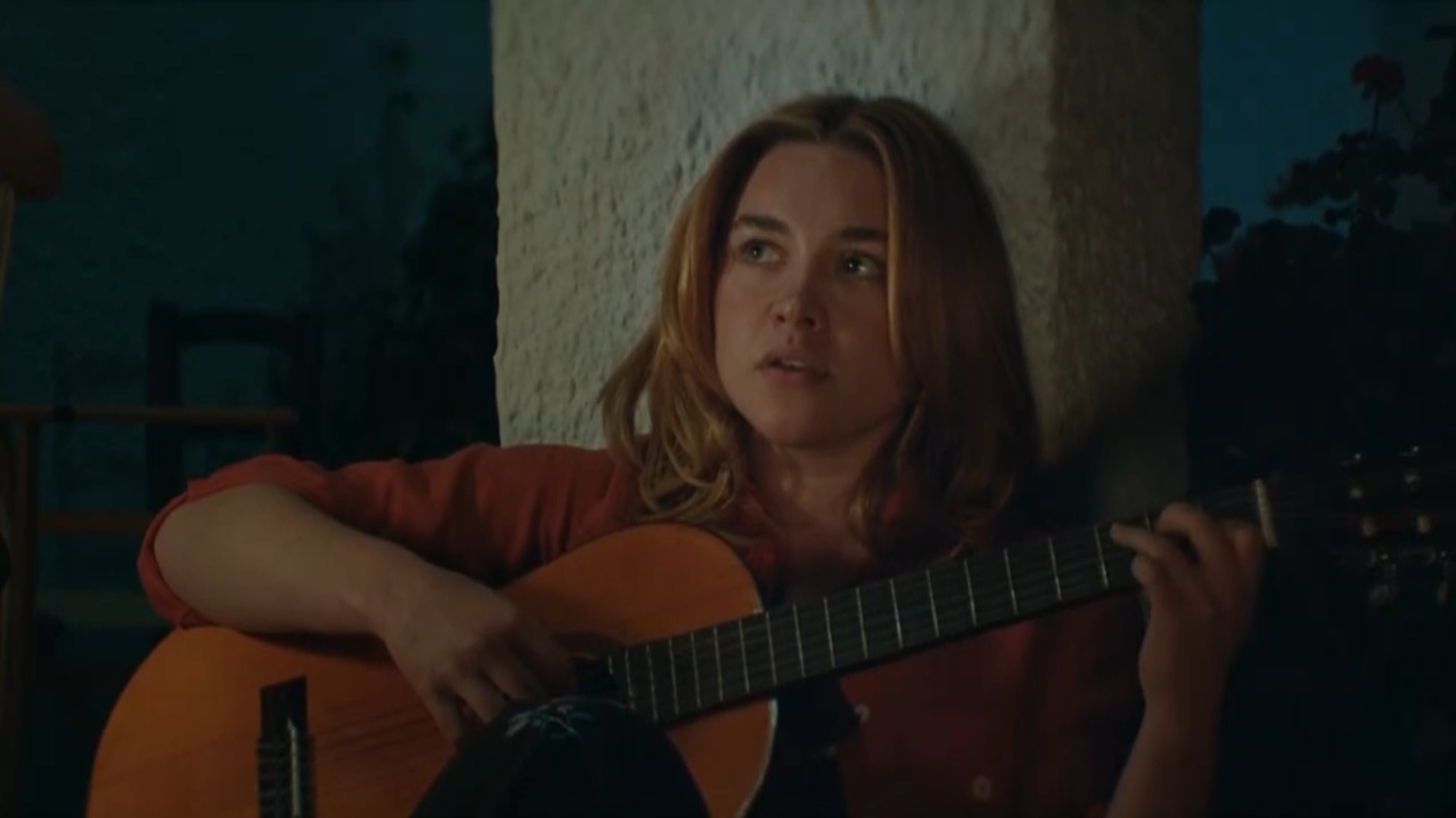 A woman plays a guitar