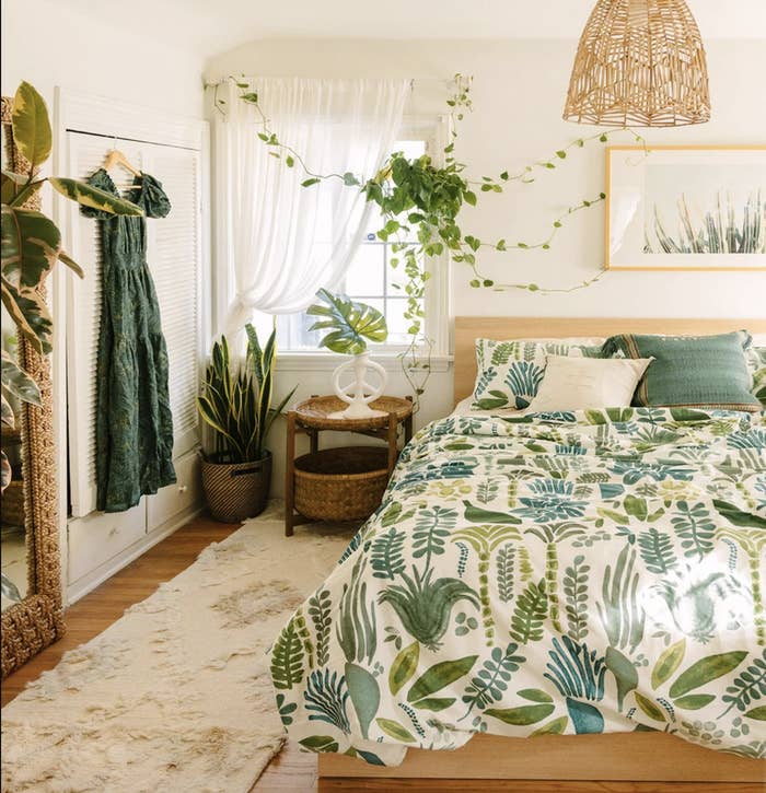 A beautiful bedroom with many green tones and plants and decor
