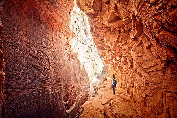 a lone hiker walking through the zion national park narrows