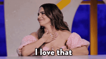 Woman putting her hand to her chest and saying &quot;I love that&quot;