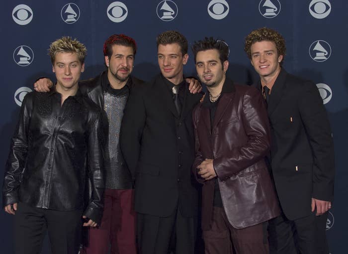 Members of NSYNC on the red carpet, in suits and leather jackets