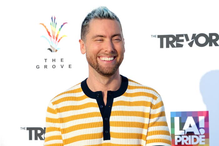 A smiling Lance Bass in a striped top on the red carpet