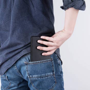 A person placing the folded keyboard into their back pocket