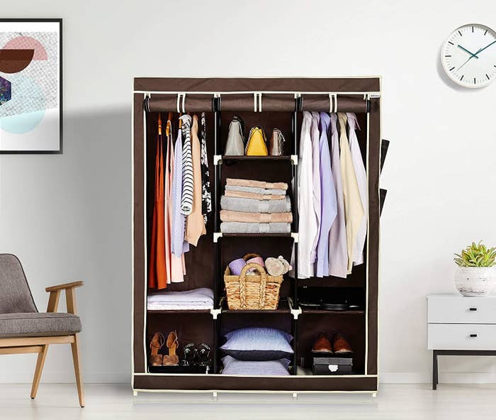 A foldable 3-door wardrobe that is filled with clothes, shoes, baskets and pillows
