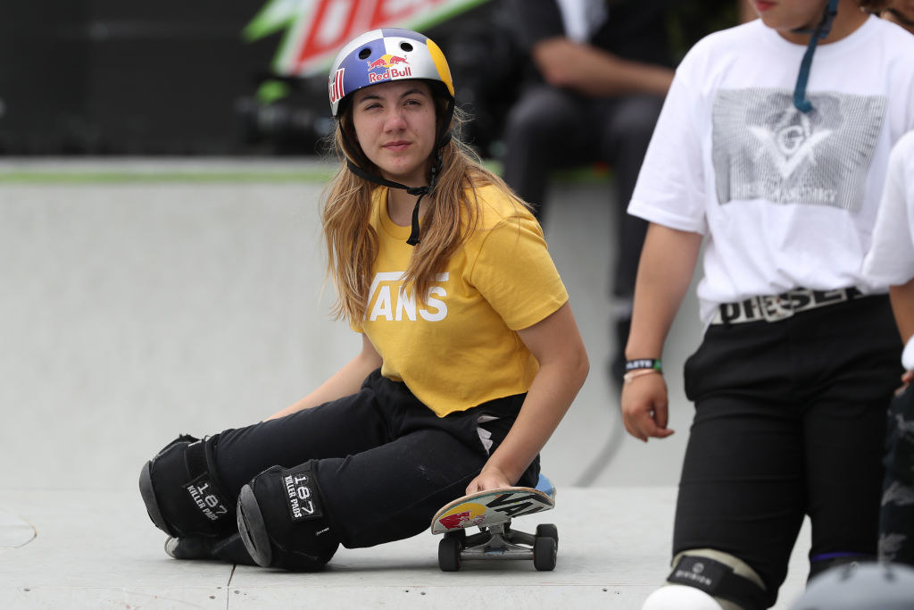 Brighton sitting on her skateboard during a competition