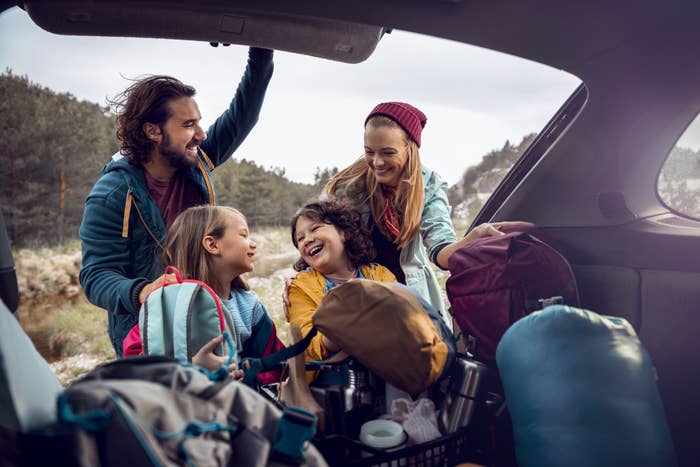 A family unpacking their trunk preparing for a hike