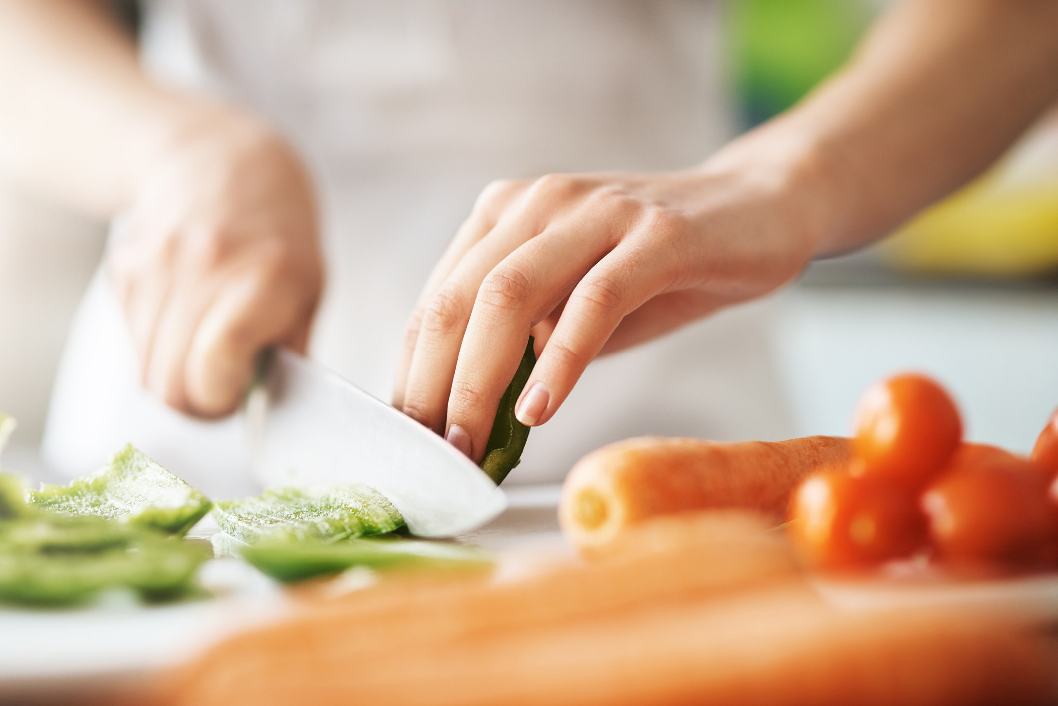Close-up of hands chopping veggies