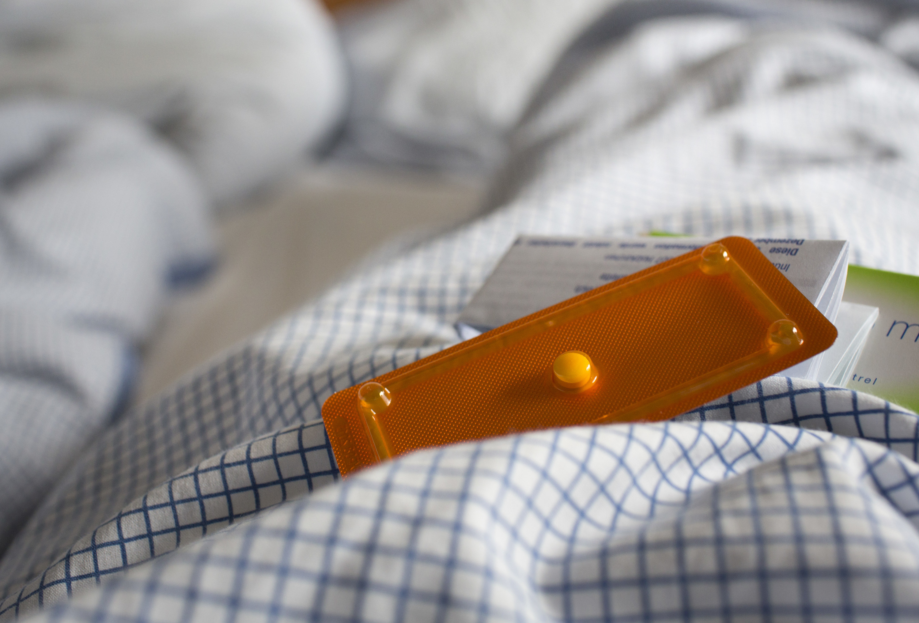 An image of a pill sitting atop a hospital gown