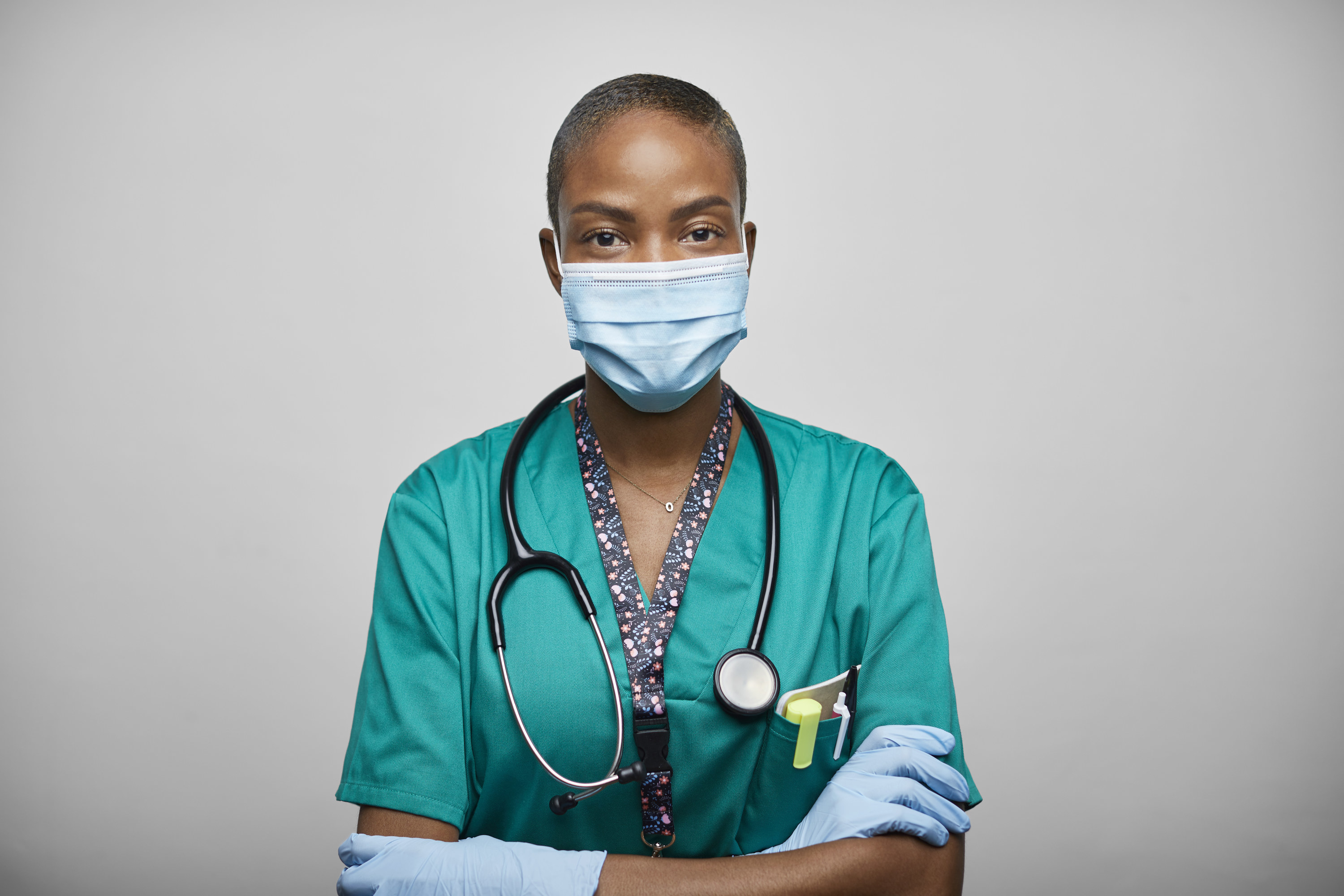 An image of a doctor wearing a medical coat and a face mask