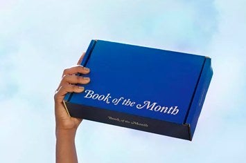 a hand holding a Book Of The Month Club box 