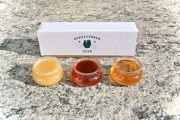 three jars of variously colored honeys