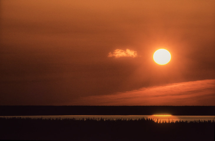 Photo of midnight sun over a river in northwest territories