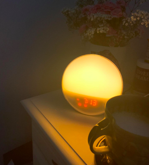 A reviewers lit alarm clock on their nightstand